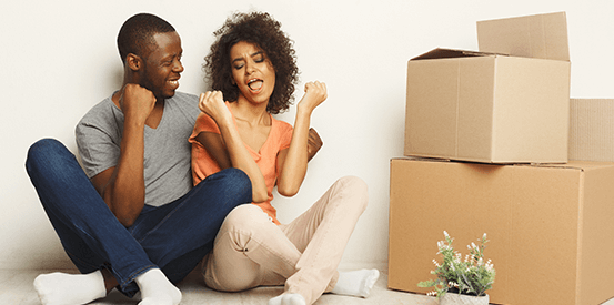 Couple posing beside moving boxes