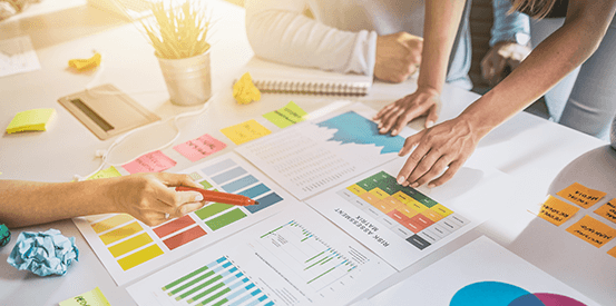 three people looking at charts and graphs