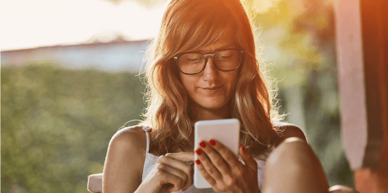 Female with glasses looking at her phone