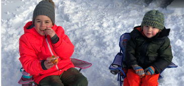 two kids winter image 365X170 Two girls enjoying snacks on a winter day
