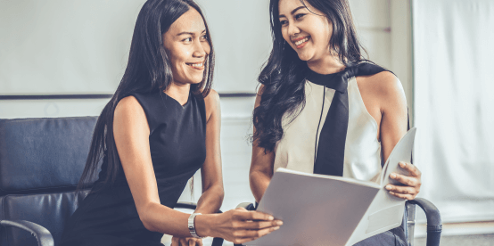 two women meeting and discussing a file