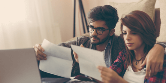 male and female couple looking at a sheet of paper