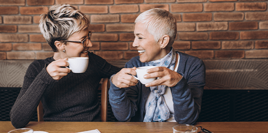 Two woman laughing in a cafe