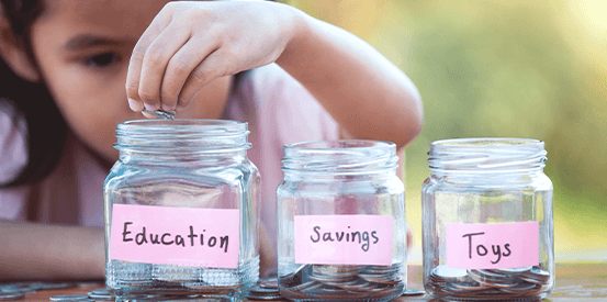 Young girl saving money in jars