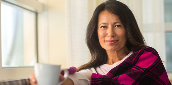 Save Woman Coffee person sitting on a couch holding a white coffee mug