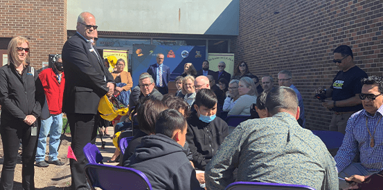 Synergy staff listening to drummers at the LCHS groundbreaking ceremony