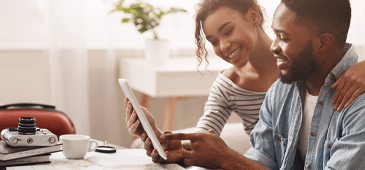 smiling couple looking at a tablet