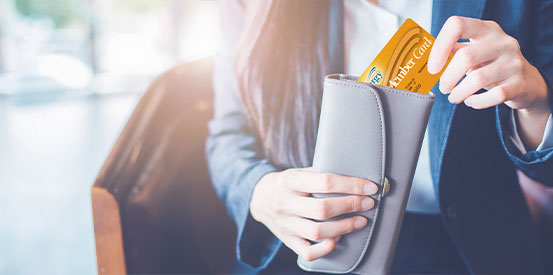 Person pulling a Synergy debit card from a wallet