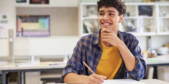 Male student smiling in a classroom